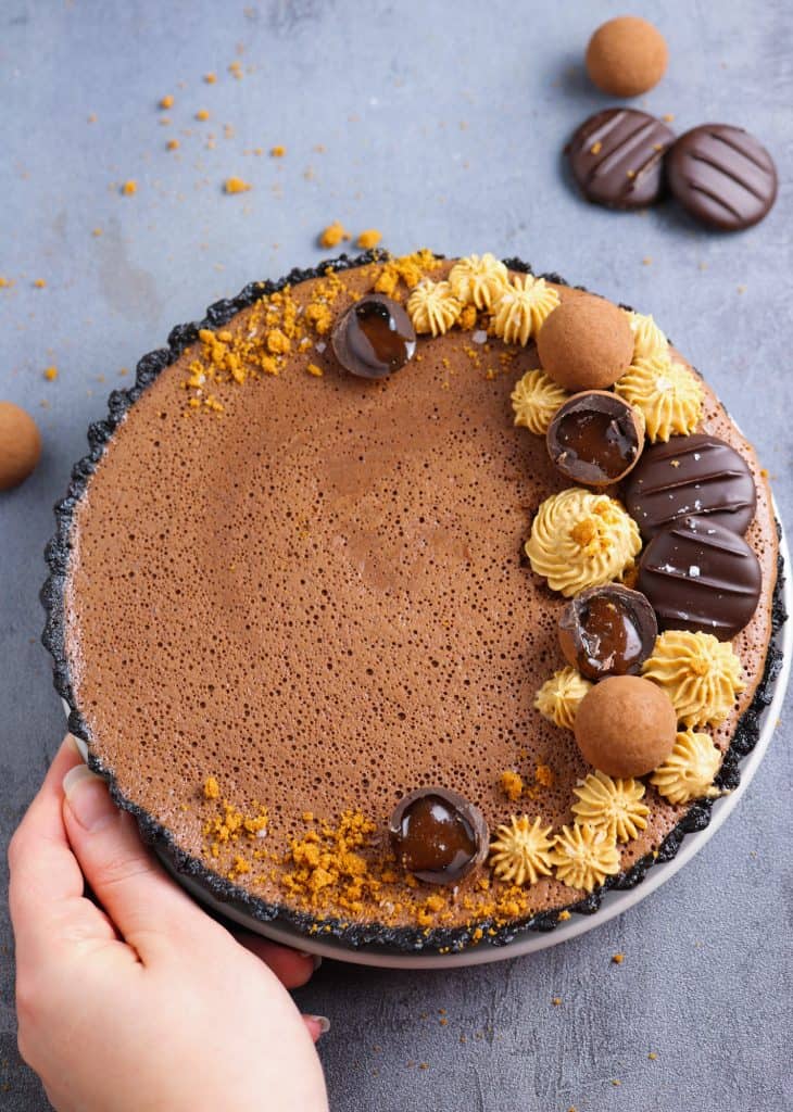 Chocolate Mousse and Biscoff Tart with an hand next to the plate