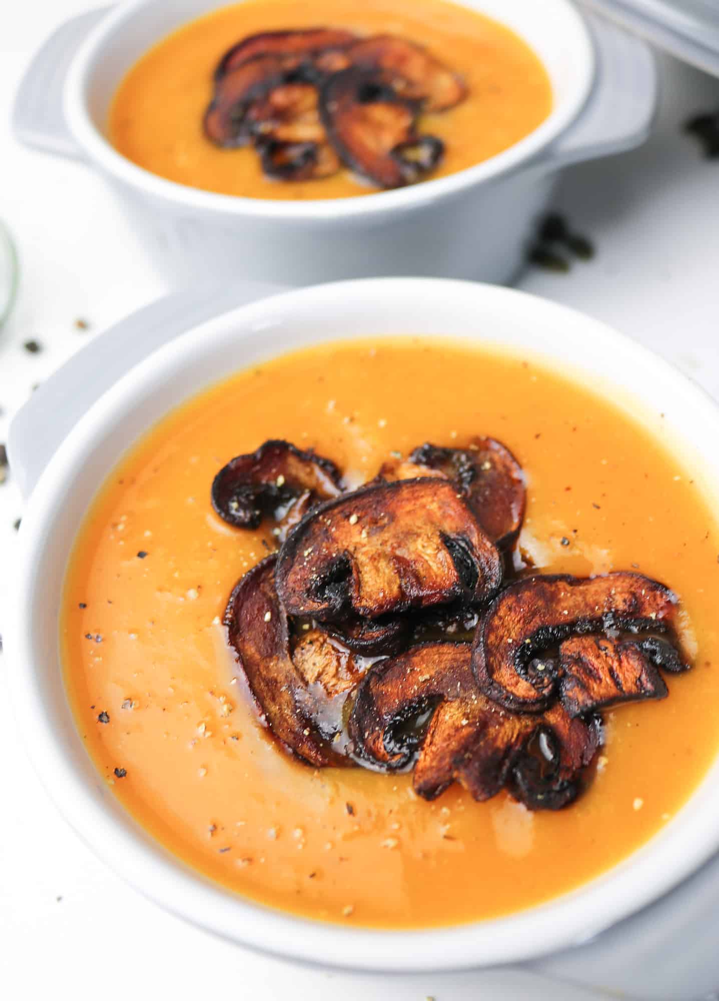 This roasted pumpkin soup with mushroom "bacon" bits in 2 grey porcela pots