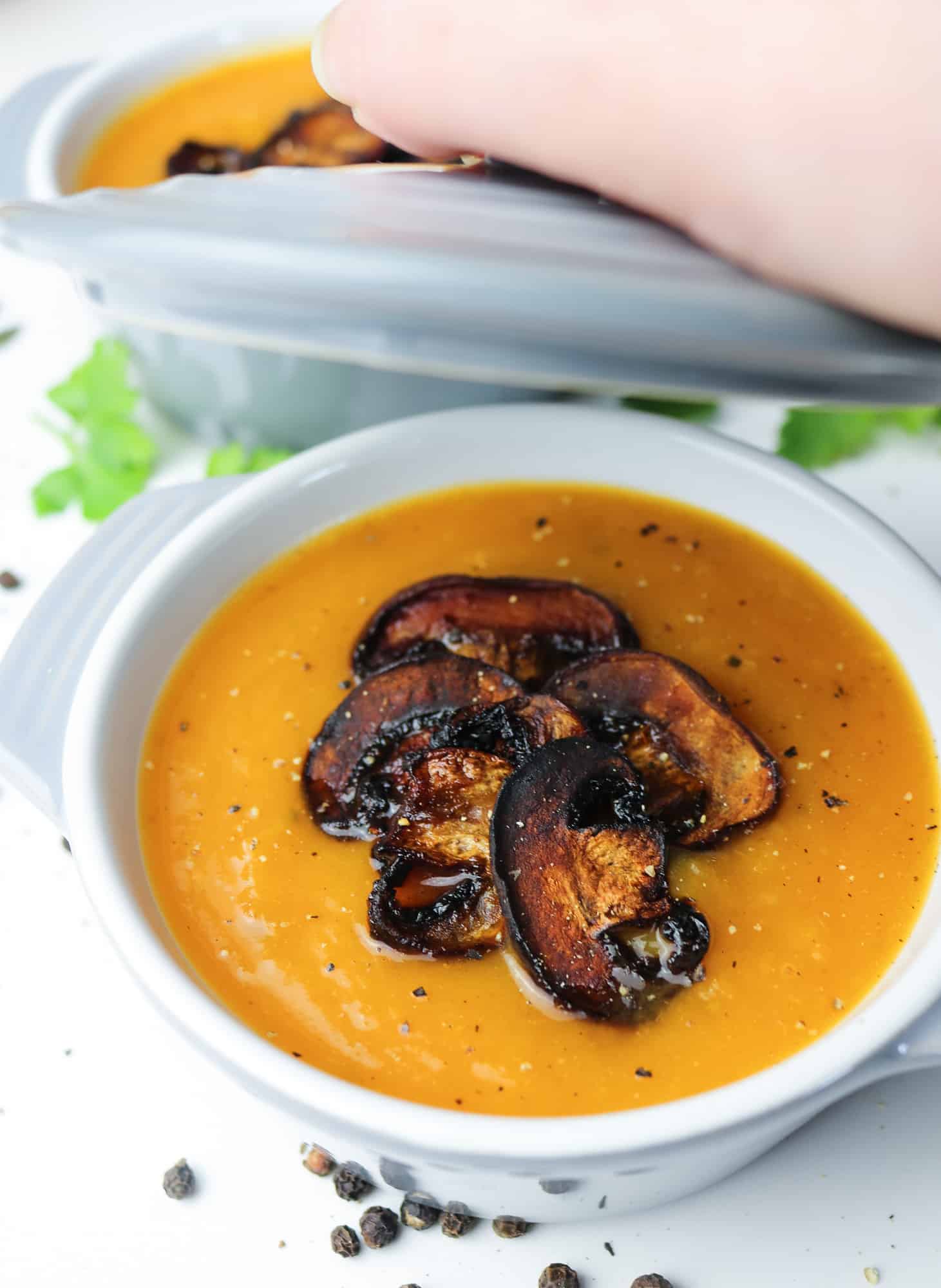 This roasted pumpkin soup with mushroom "bacon" bits with hand lifting the lid
