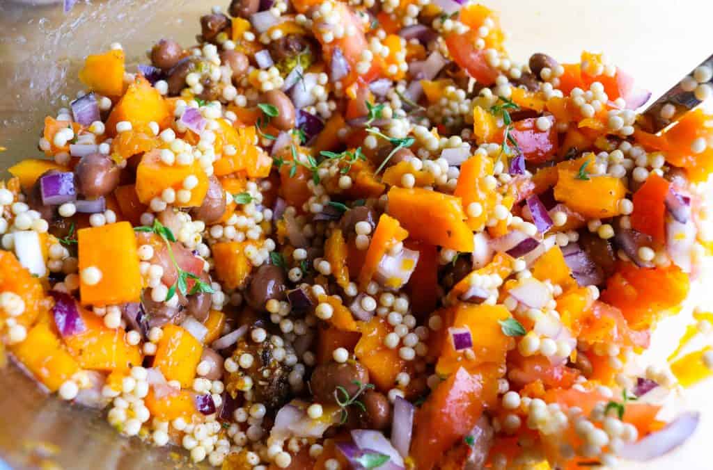 coloratissima immagine del ripieno della Zucca al Forno con couscous gigante, cubetti di zucca, cipolla rossa, fagioli borlotti ed erbe varie