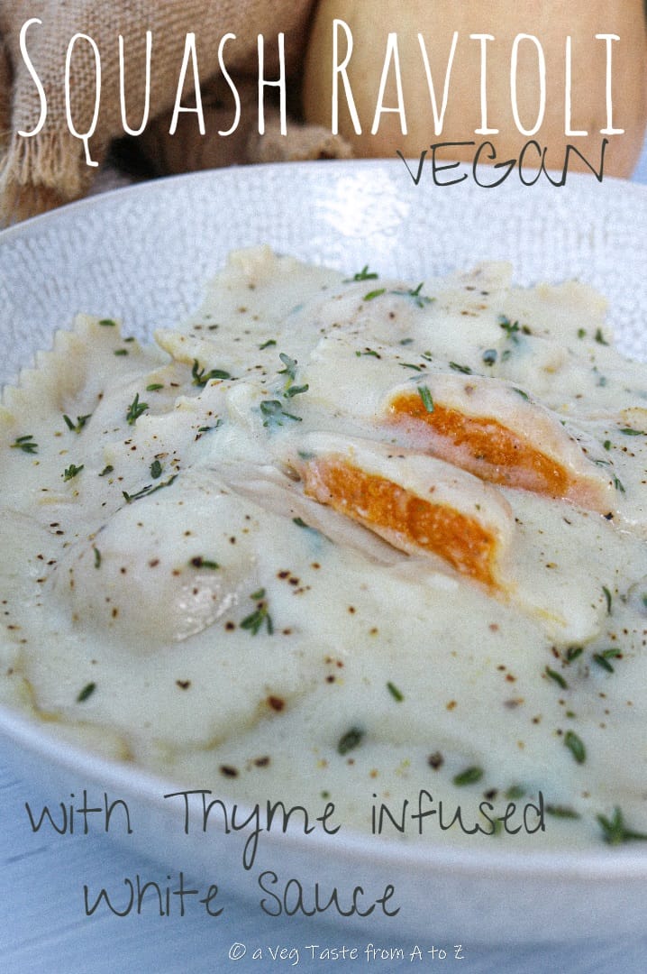 butternut squash ravioli served with thyme infused white sauce on a white plate close up to filling reveal