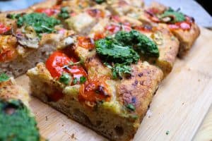 Focaccia con funghi freschi, pesto di spinaci e anacardi, pomodori e crescione.