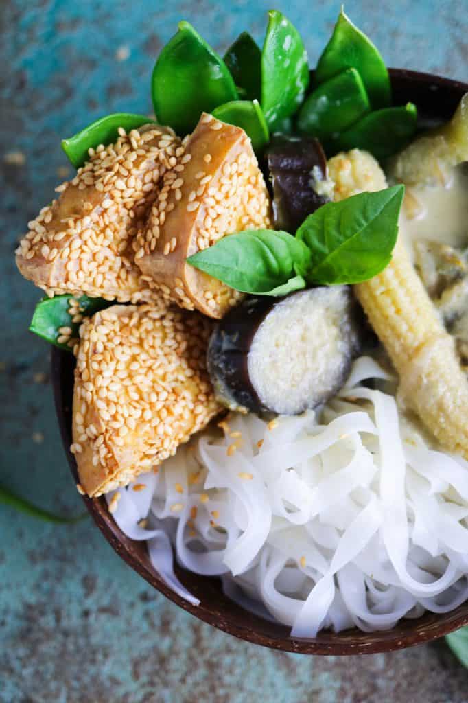colourful close up on crispy sesame tofu in a bowl with vegan Thai Green Curry and rice noodles