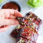 rib like tofu covered in bbq sauce with a piece held between two fingers