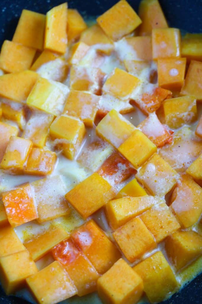 cubed butternut squash in a pan with plantbased milk for 