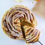 flaky apple tart with a slice on dessert spatula