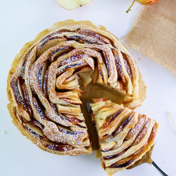 flaky apple tart with a slice on dessert spatula