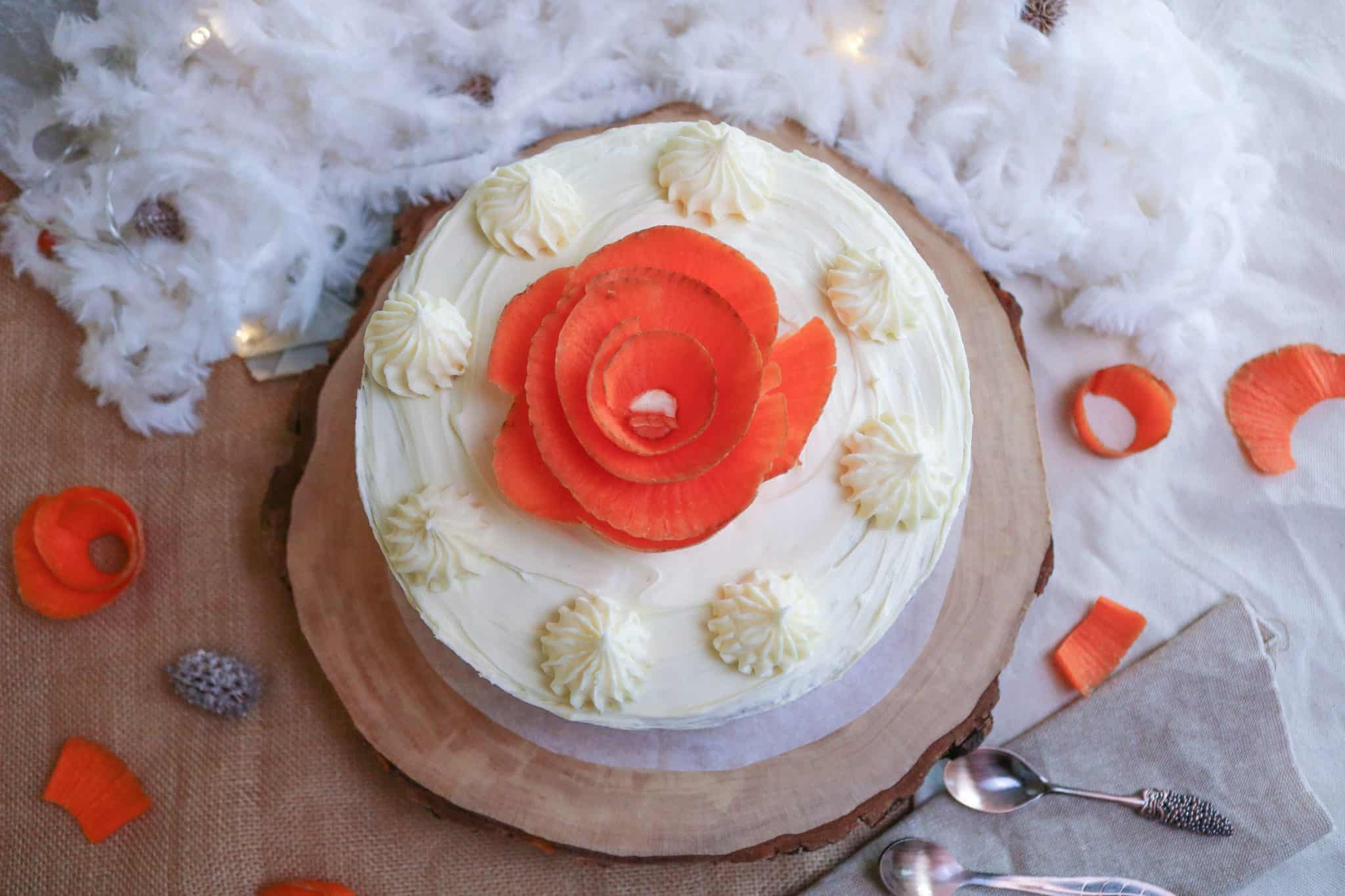 Vegan carrot cake with withe icing and carrot rose photographed from the top