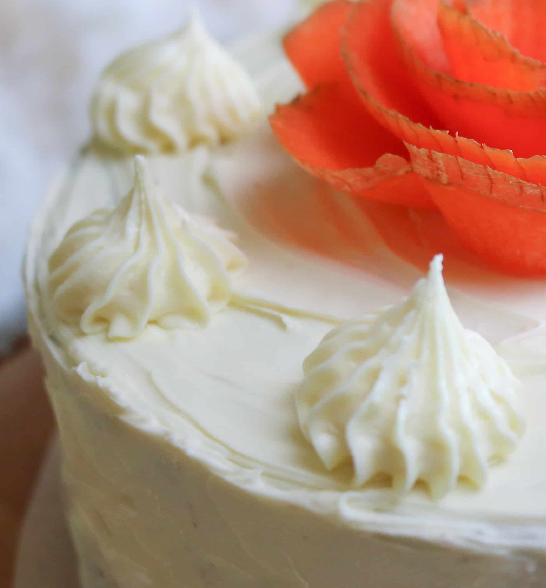 close up to frosting pipework on top of the vegan carrot cake with a twist