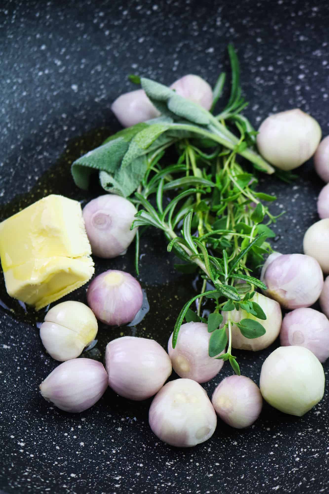 shallots with vegan butter and herbs in a pan