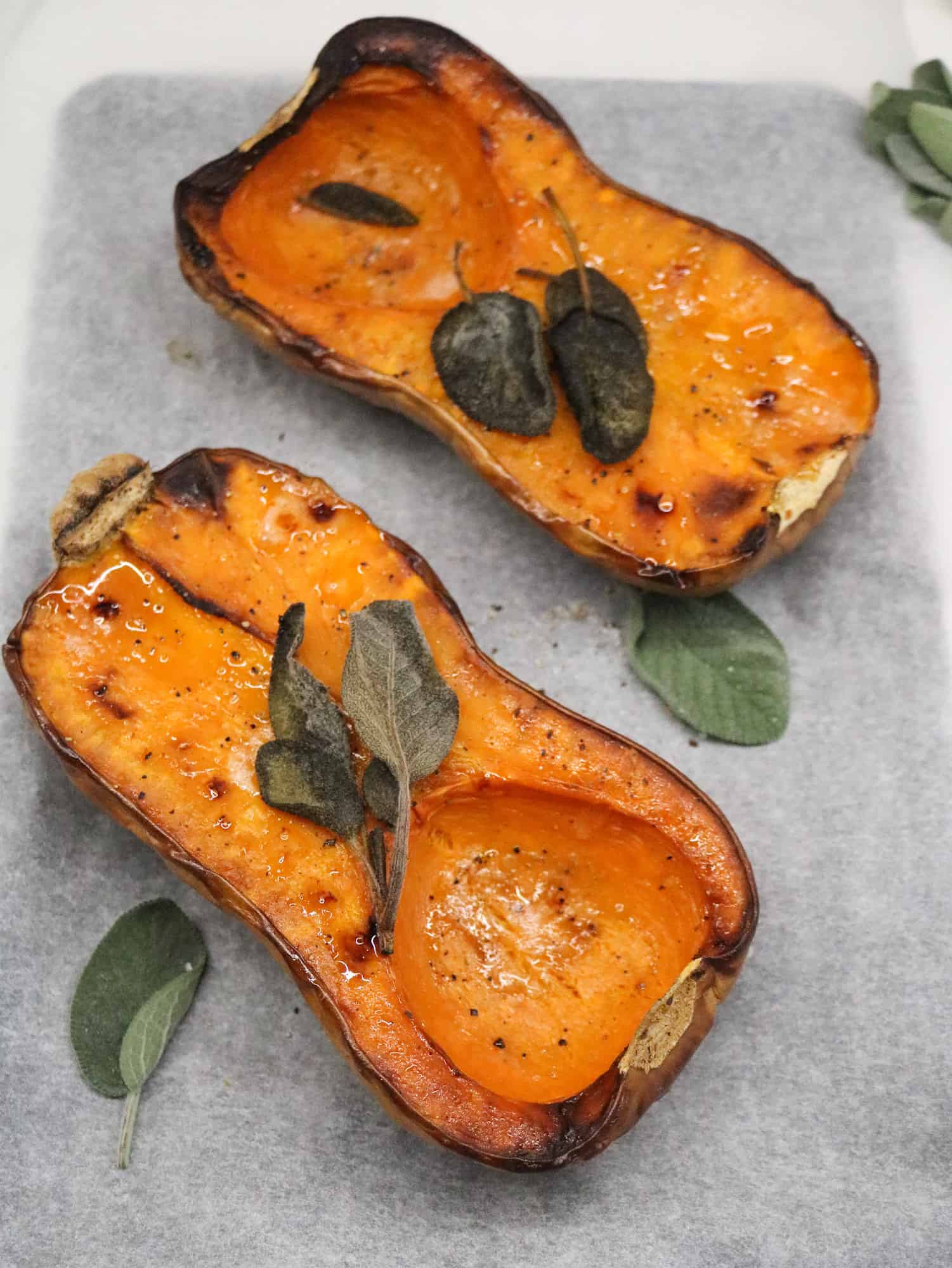 Roasted Butternut squash with fresh sage leaves on a oven tray