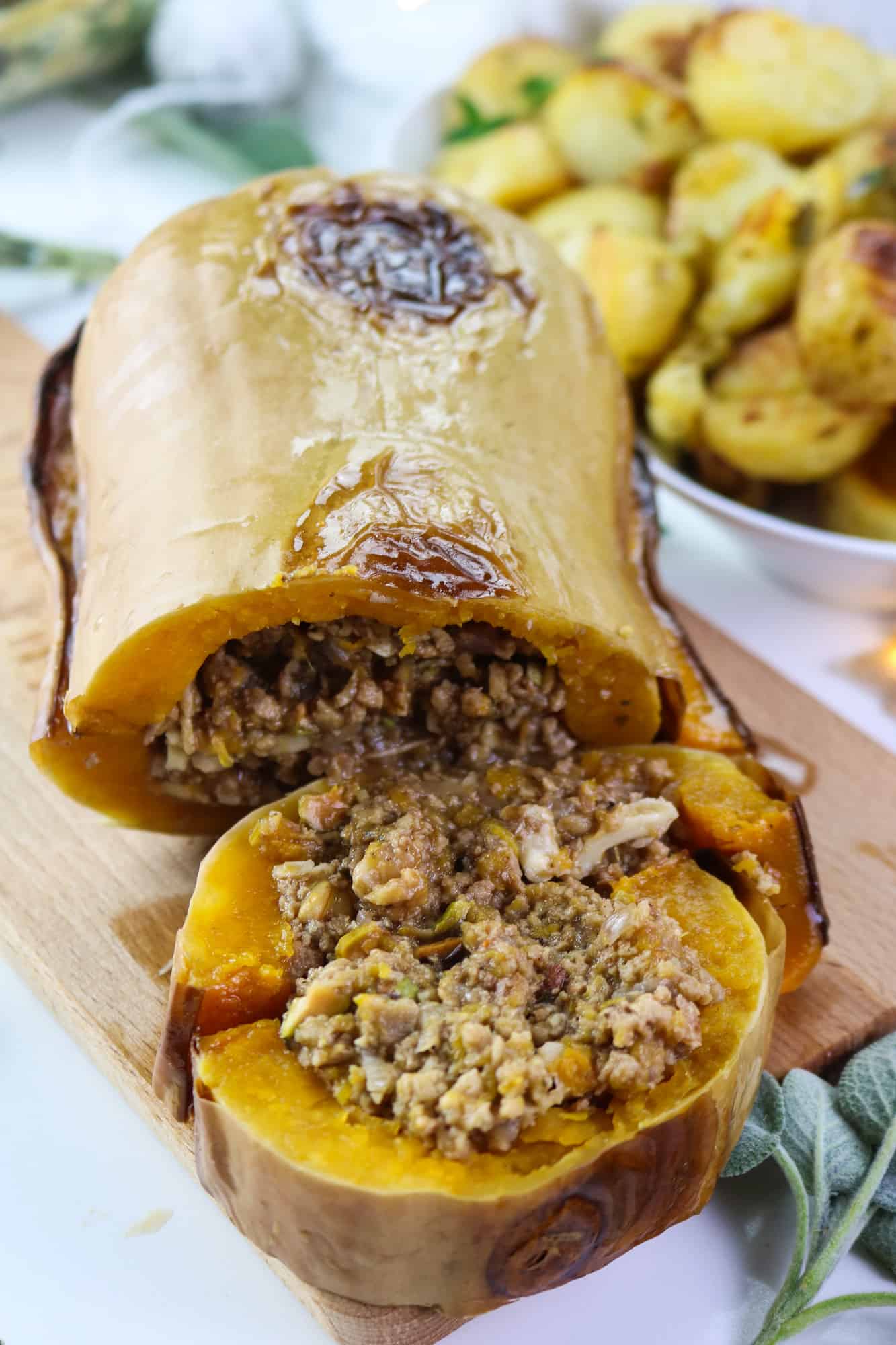 Vegan Roasted Butternut Squash: Sweet and herby roasted squash filled with a generous and fragrant plant mince, accompanied by a flavourful sage and white wine gravy, will be the absolute star of your Thanksgiving or Christmas table. #holiday #veganmain #thanksgiving #recipeinspo #plantbased #christmasmain #roastedsquash