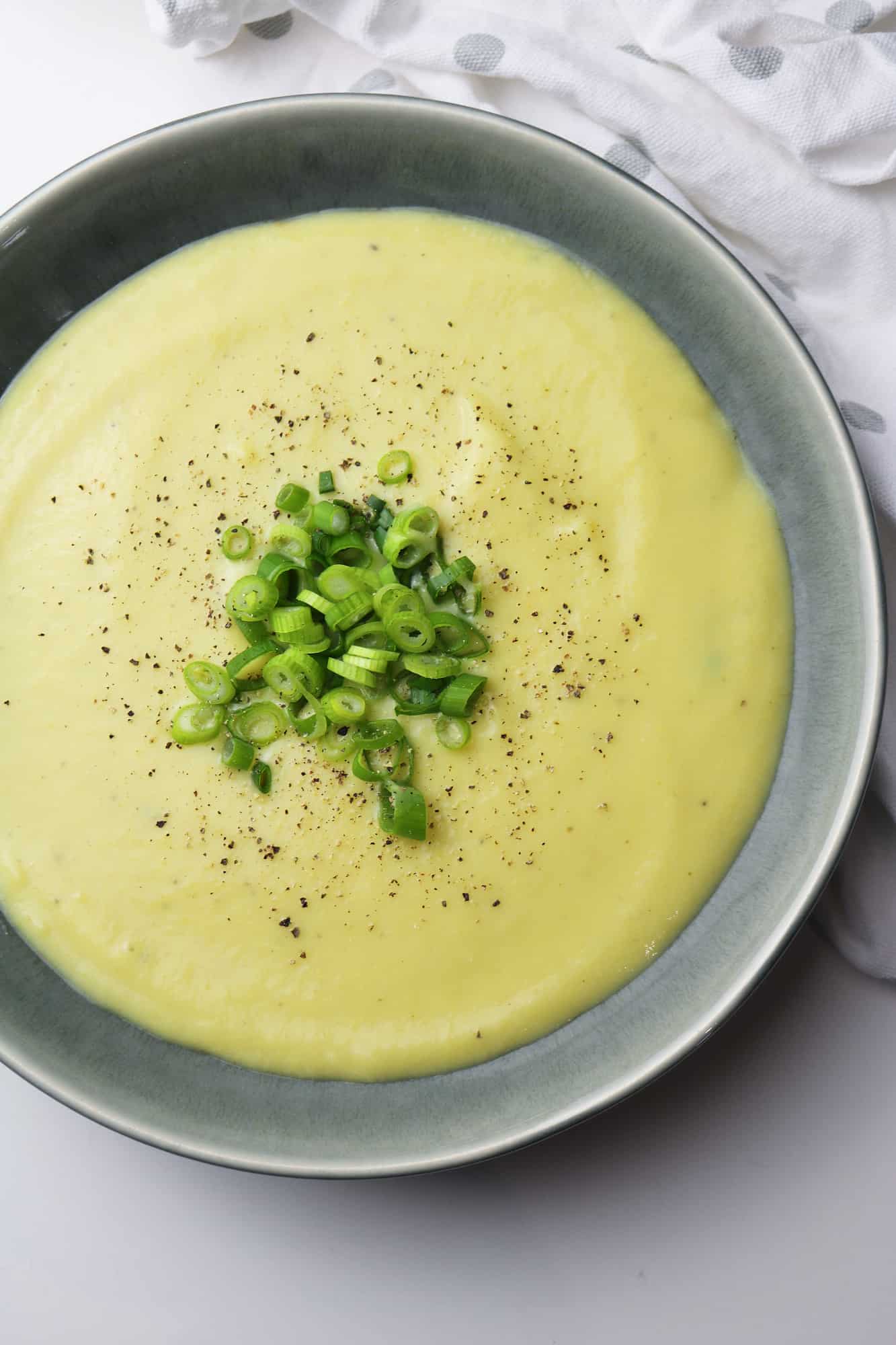 Vegan Leek and potato soup served in grey plate half pictured