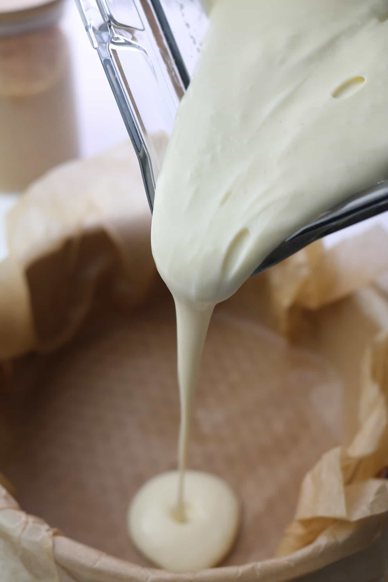 pouring the cheesecake mix in the tray