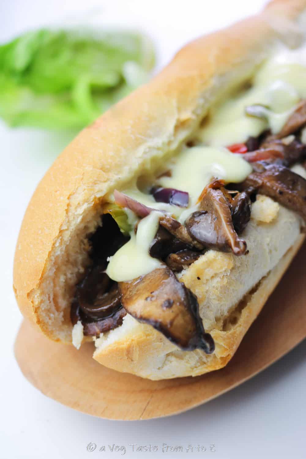 close up to vegan philly cheesesteak with oozing cheese sauce and vibrant veggies