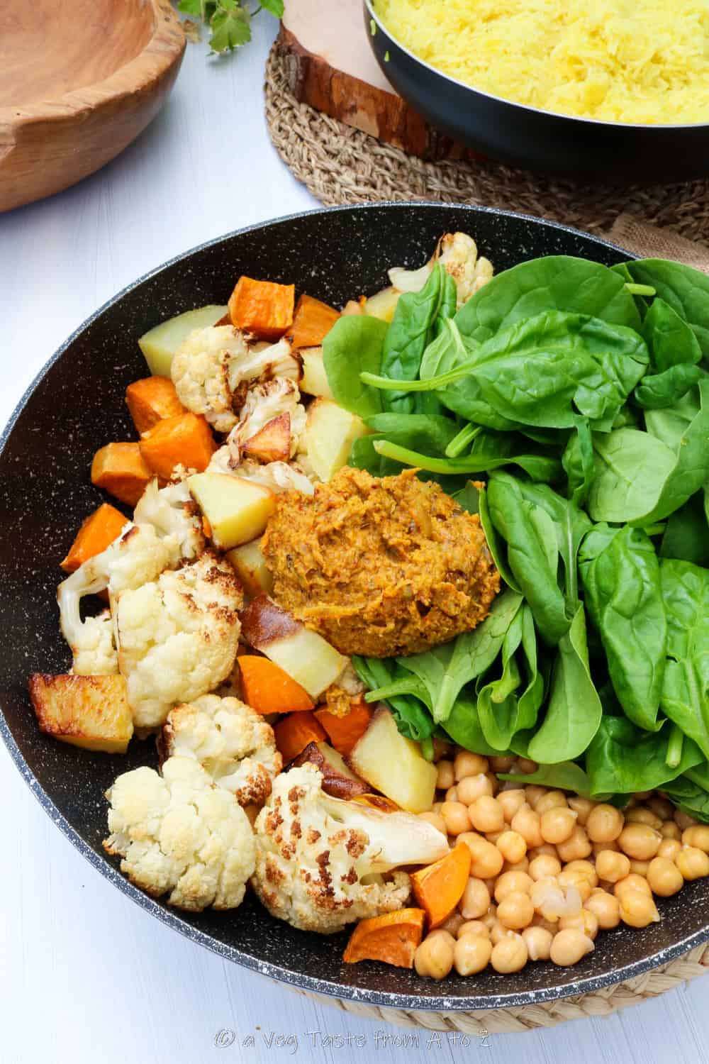 roasted vegetables, fresh spinach and spice paste in a wok