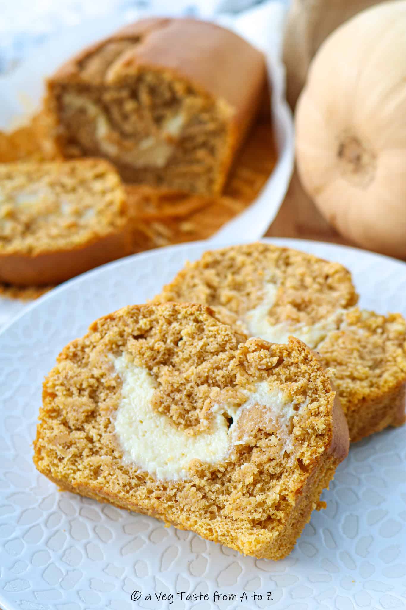 two pound cake slices on a white plate showing the cheesecake filling