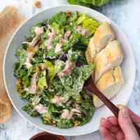 vegan chicken salad in plate with bread a wooden spoon held by hand