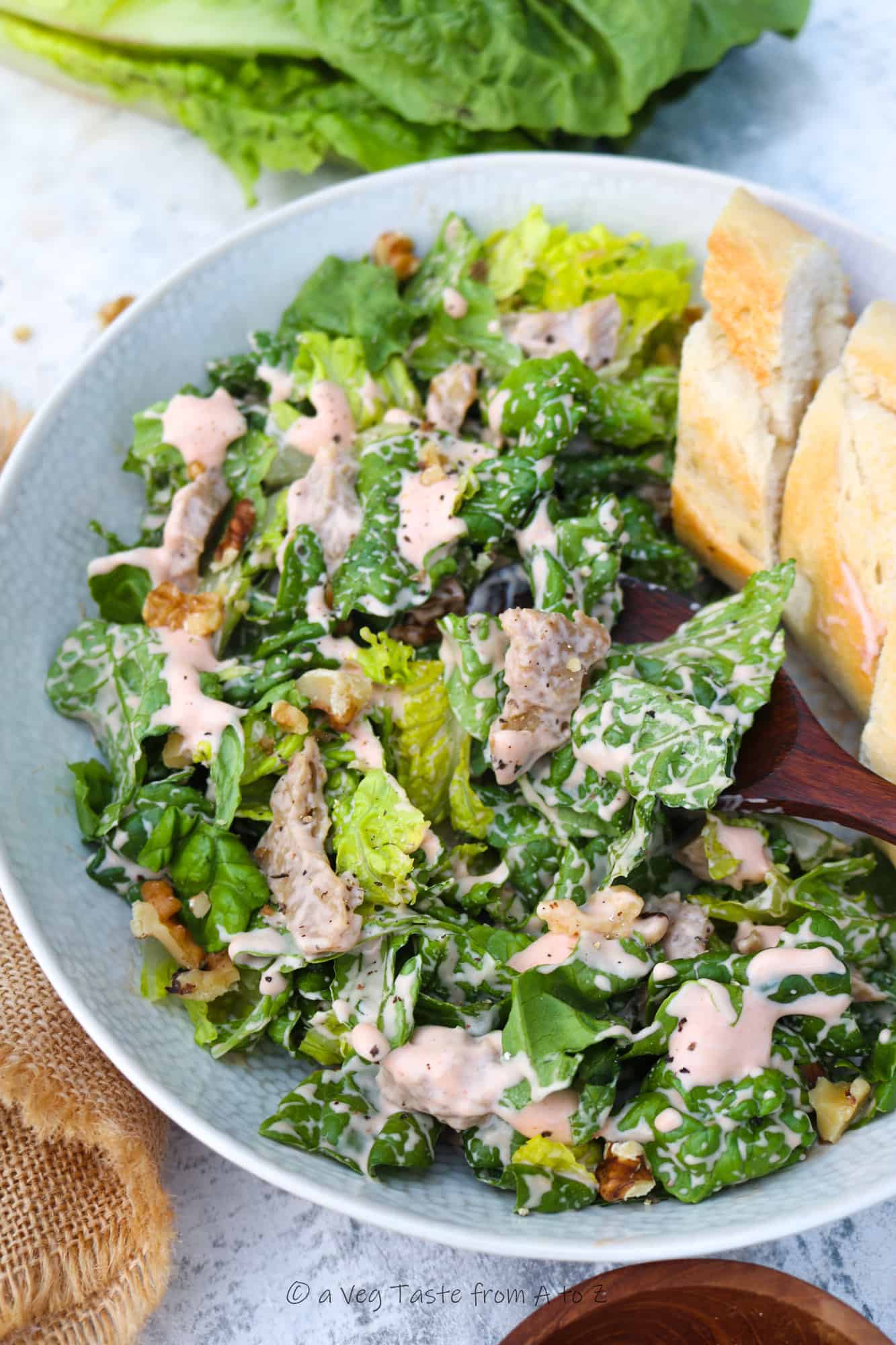 vegan chicken salad in plate with bread a wooden spoon close up half plate