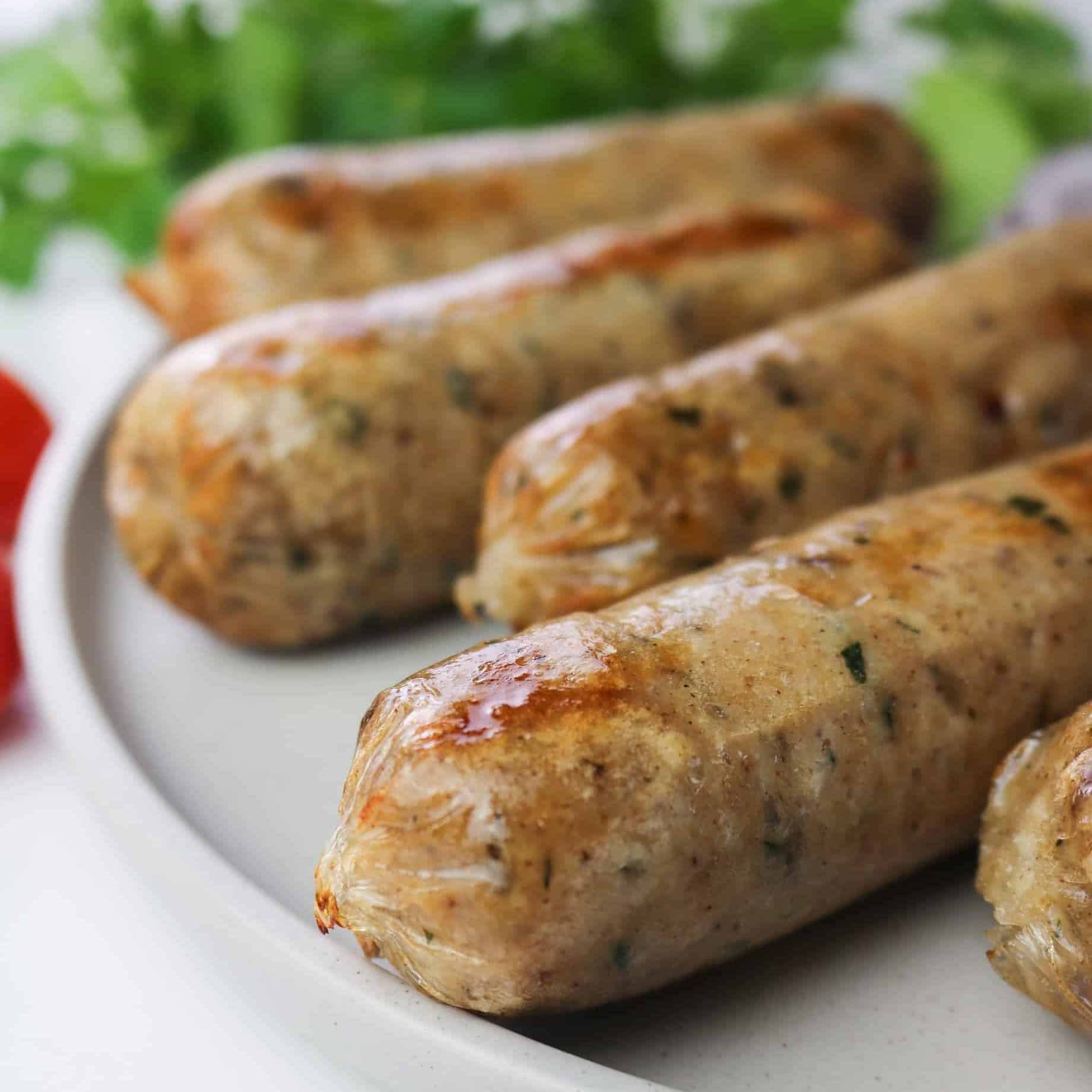 homemade vegan italian sausages with gluten roasted on a plate close up
