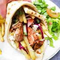 flat bread wrap filled with roasted greek style jackfruit, fries, vegetables and crumbled tofu
