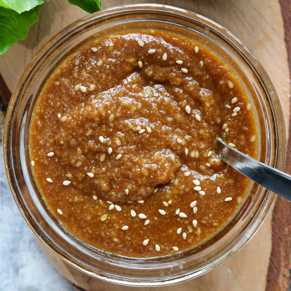 sesame and miso dressing in a glass bowl with a spoon