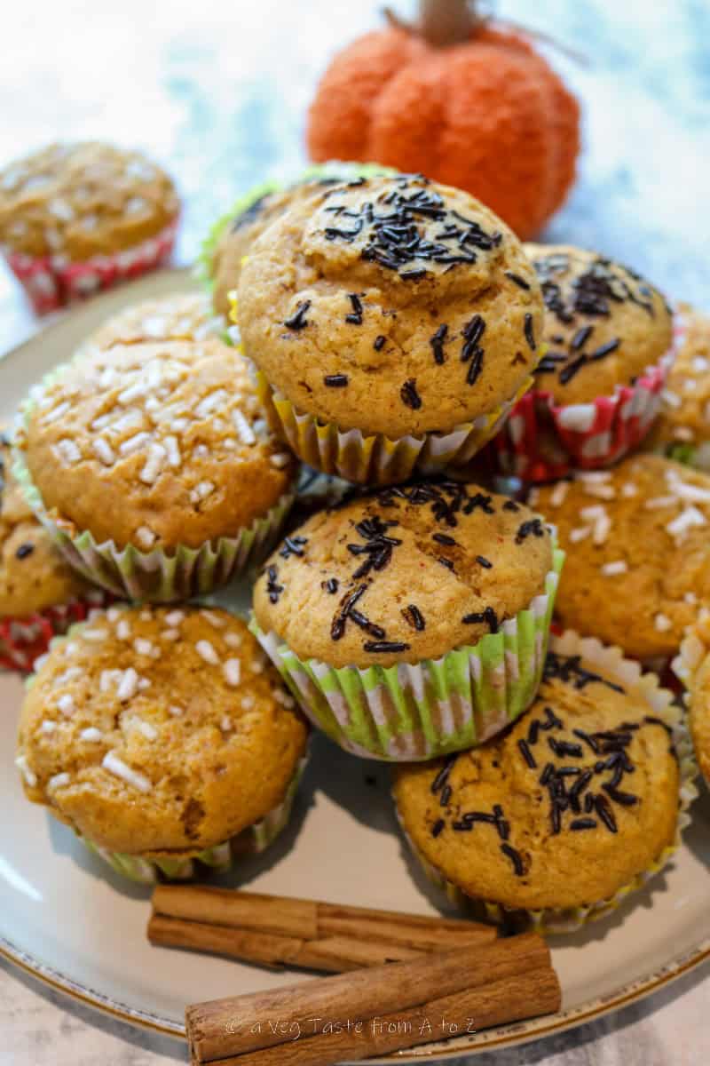 pumpkin spice muffins stacked on a plate with cinnamon sticks as decoration