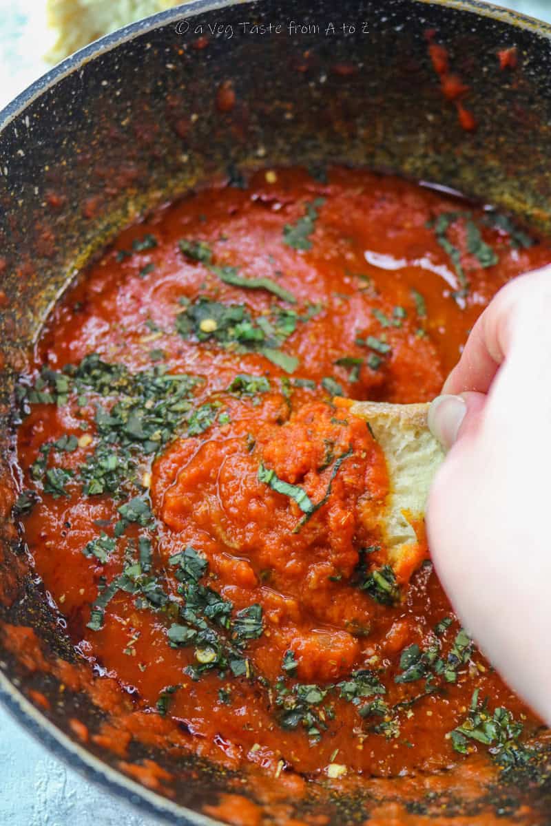 close up to bread dip into homemade marinara sauce
