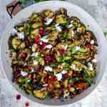 vibrant and healthy Mediterranean grilled veggie salad, loaded with charred aubergines, courgettes, vegan feta, sundried tomatoes, and pomegranate seeds.